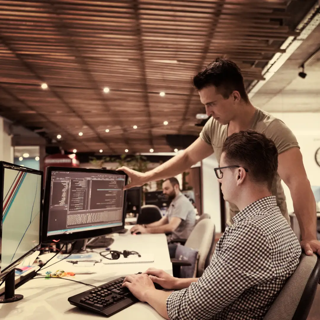 2 people looking and pointing at a screen at a web development agency