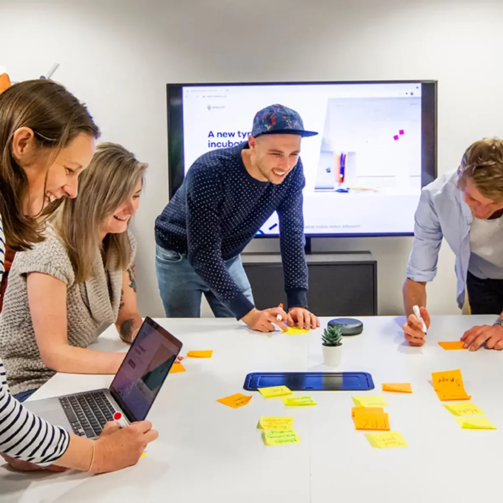 team working around desk writing on post it notes