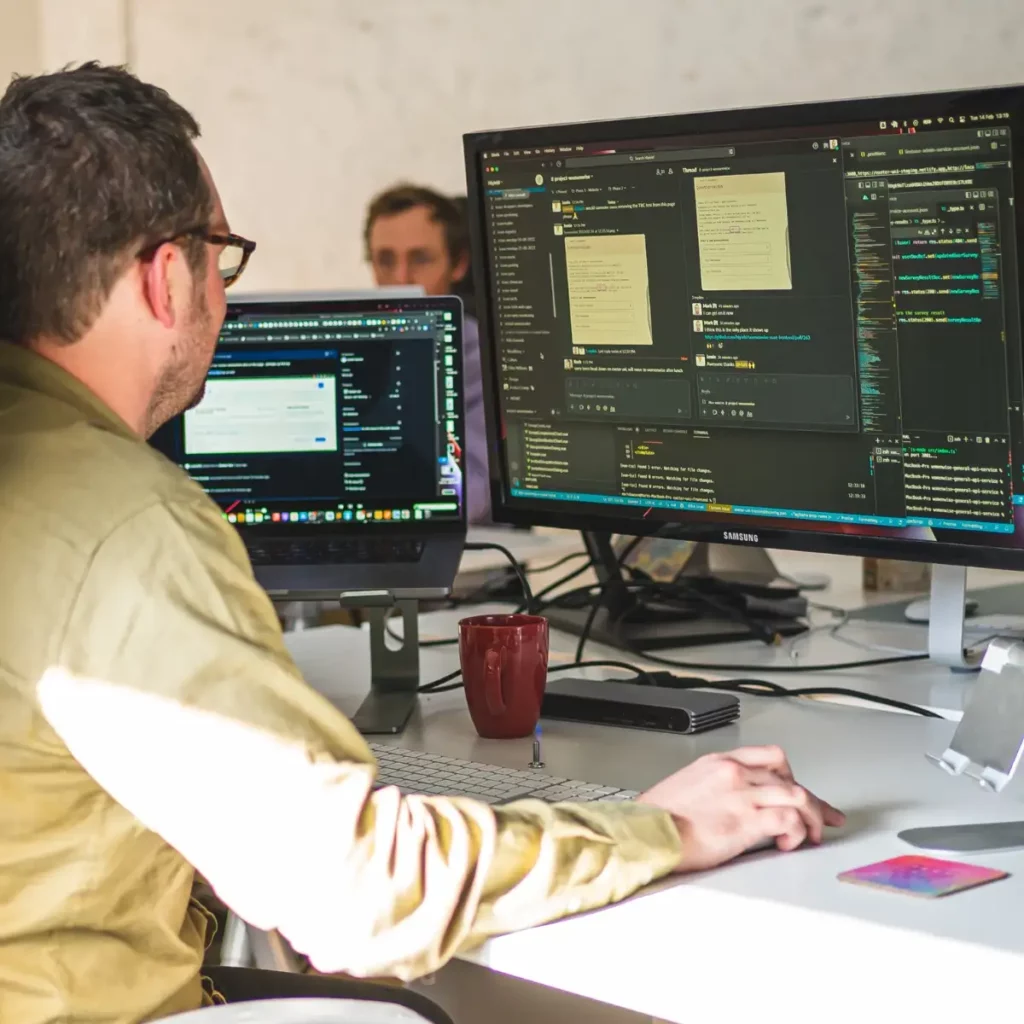 developer mark working on desktop and laptop