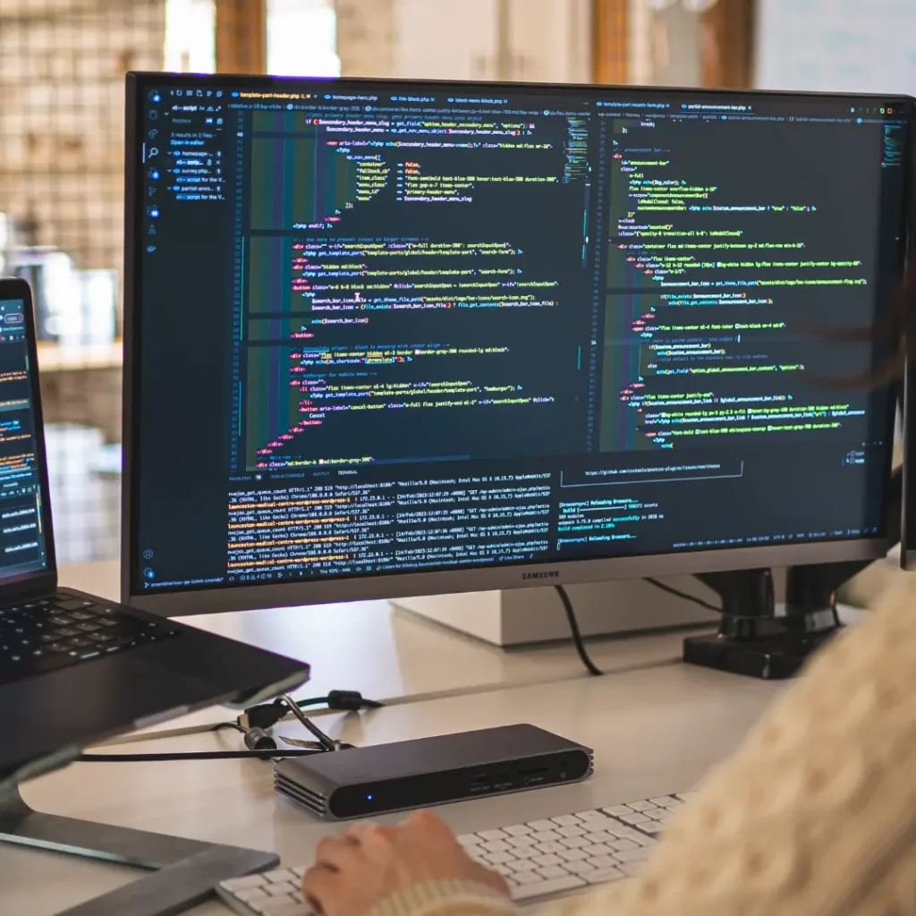 developer sat at desk working with code open on their screens