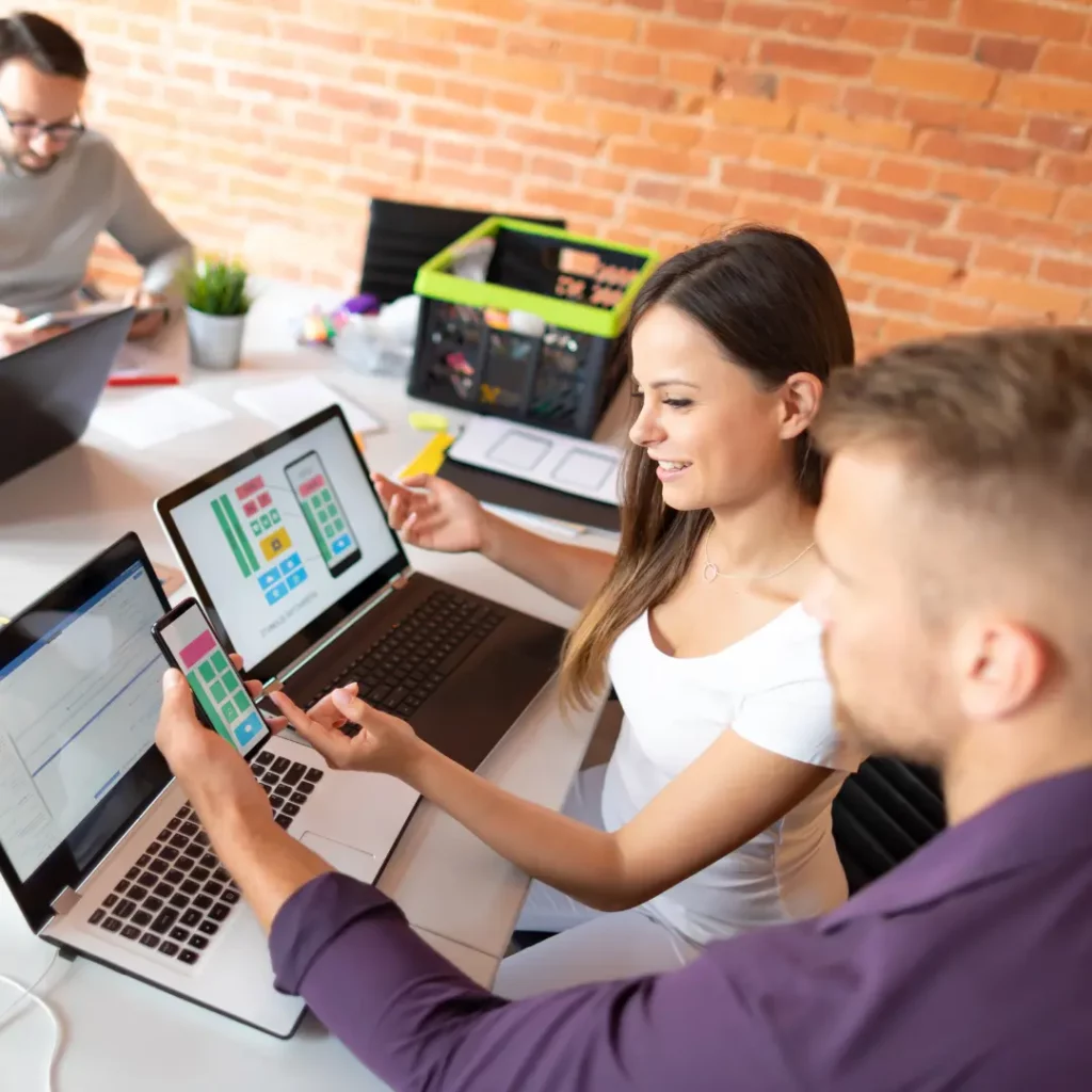 people looking at web design layout on phone and laptop