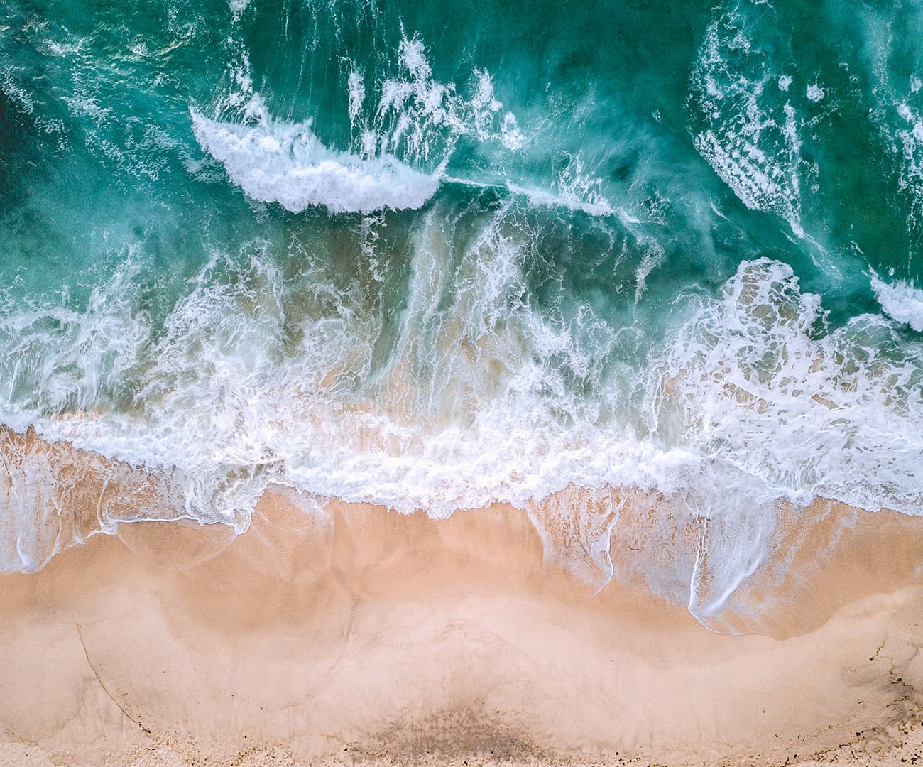 Aerial photograph of a sandy beach and waves Offshore