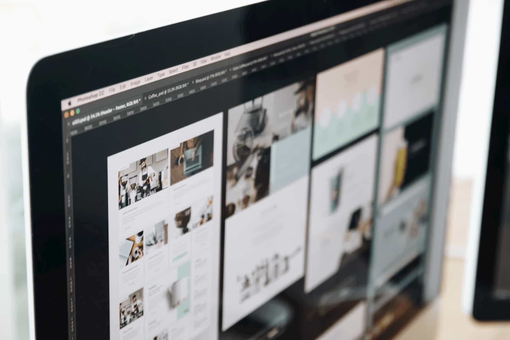 Photograph of a Imac computer with a selection of web designs on