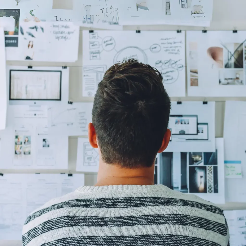 person looking at a board with papers pinned up