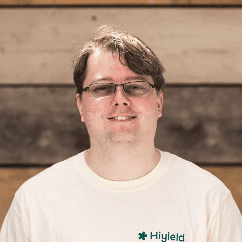 Ben Short, Hiyield Employee Director, stood in front of a wooden wall.
