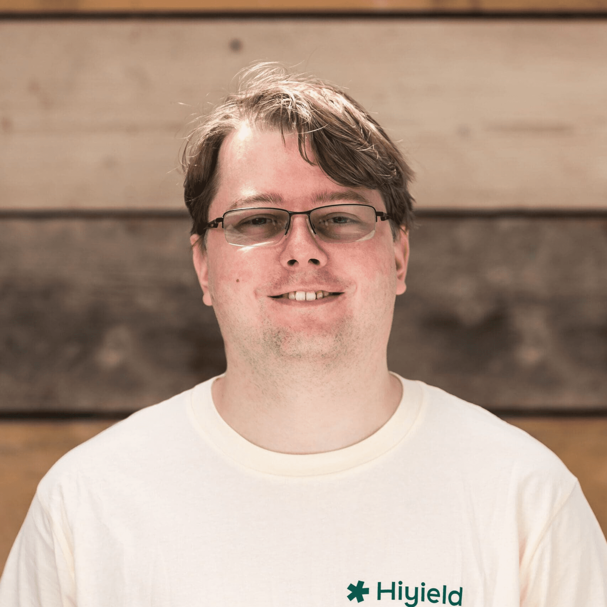 Ben Short, Hiyield Employee Director, stood in front of a wooden wall.