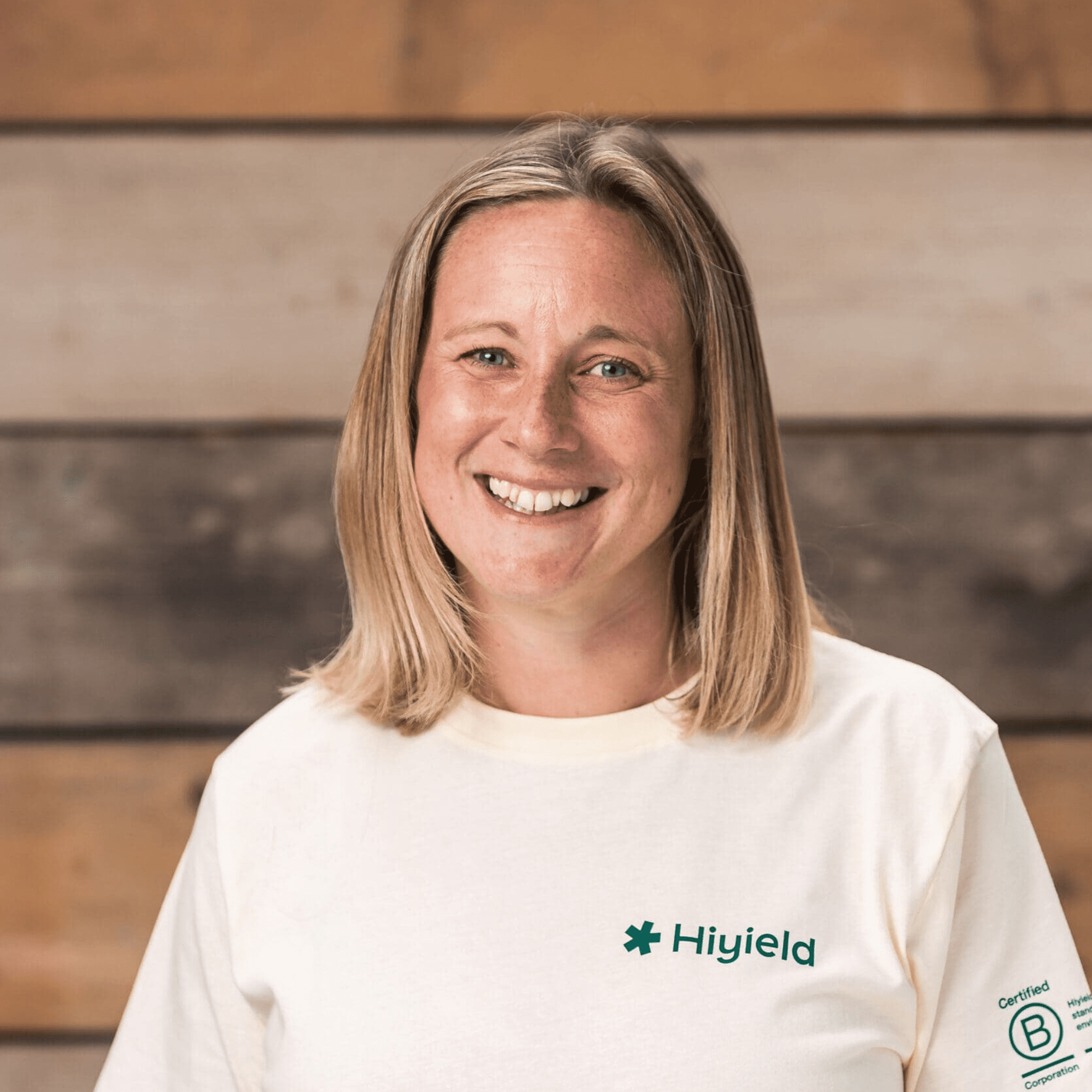 Laura Hudspith wearing a cream Hiyield B Corp t-shirt and smiling.