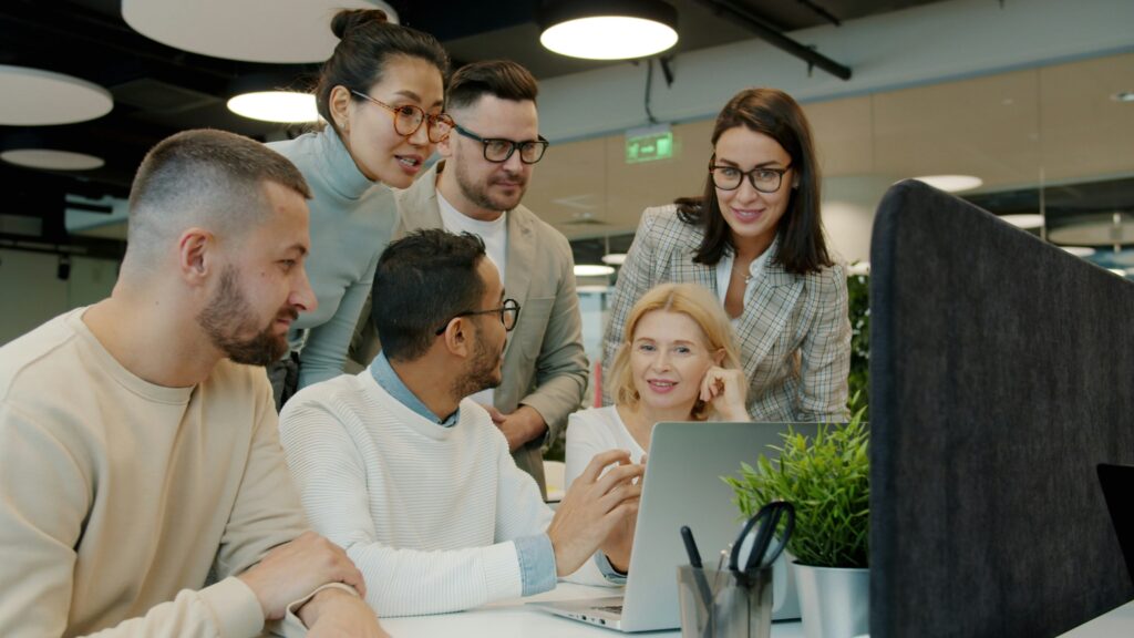 Six colleagues sat around a computer screen discussing plans for their charities.
