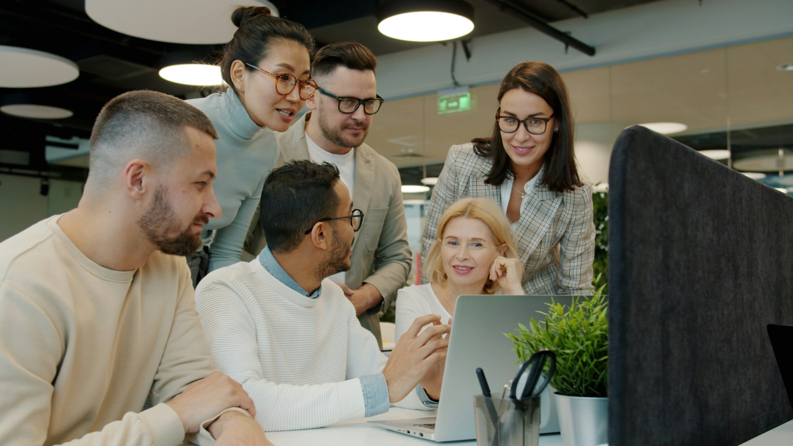 Six colleagues sat around a computer screen discussing plans for their charities.