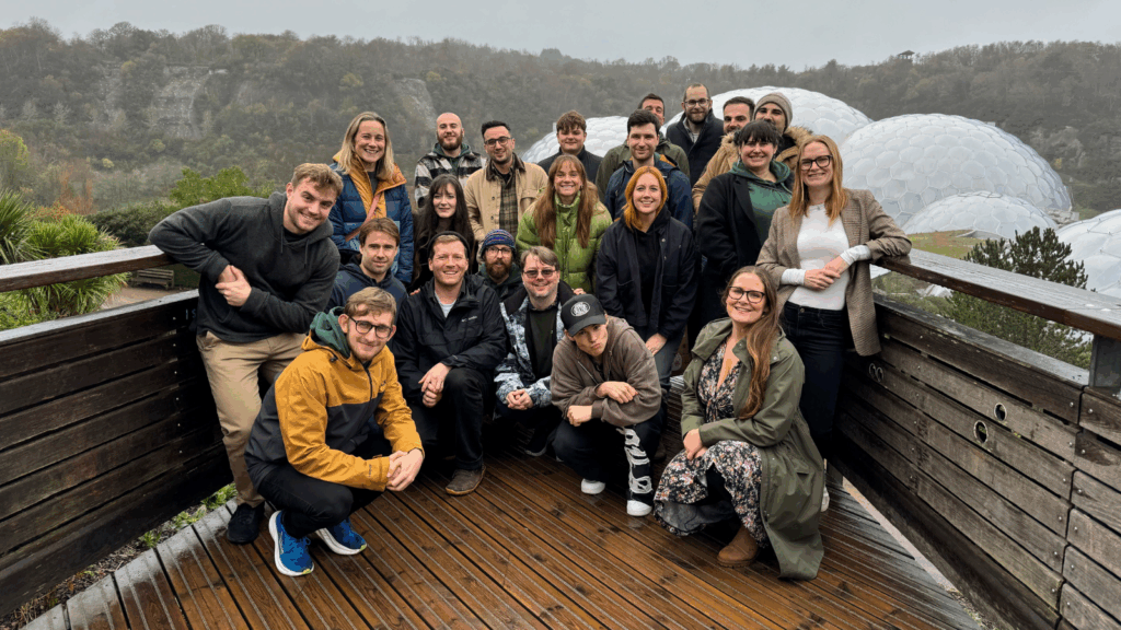 The Hiyield team on a wet day gathered on the lookout with Eden Project Biomes behind them.