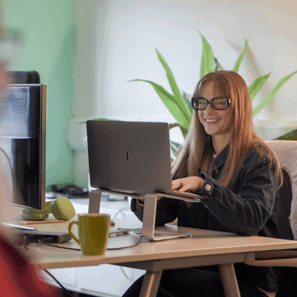 Sophie from Hiyield sat at her desk smiling, surrounded by plants.