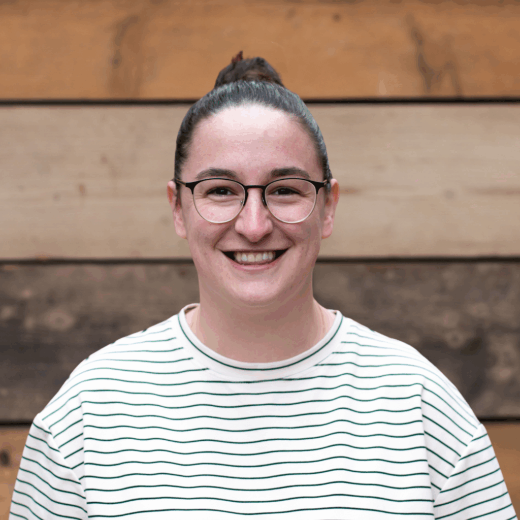 Gemma Robinson headshot against wooden wall background.