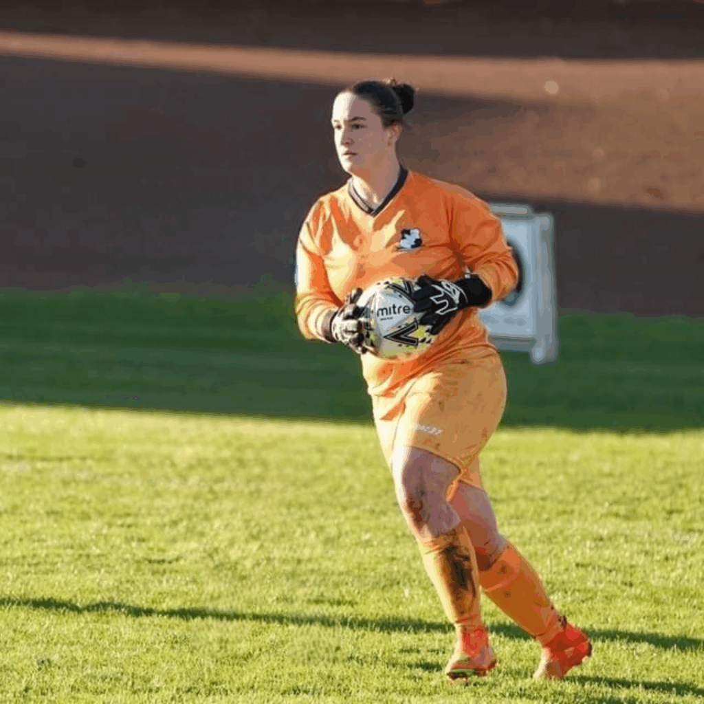 Gemma Robinson playing football as a goalkeeper in orange.
