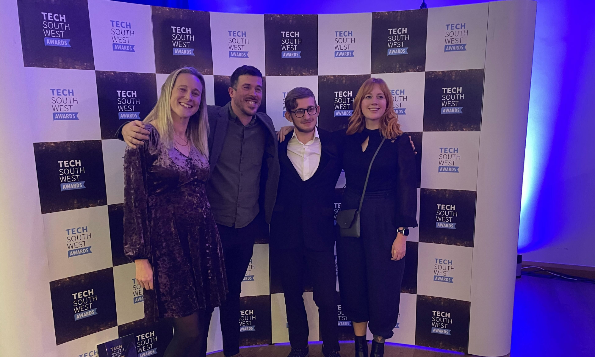 Laura, Matt, Justin and Anita from Hiyield smiling in front of the Tech South West Awards banner.