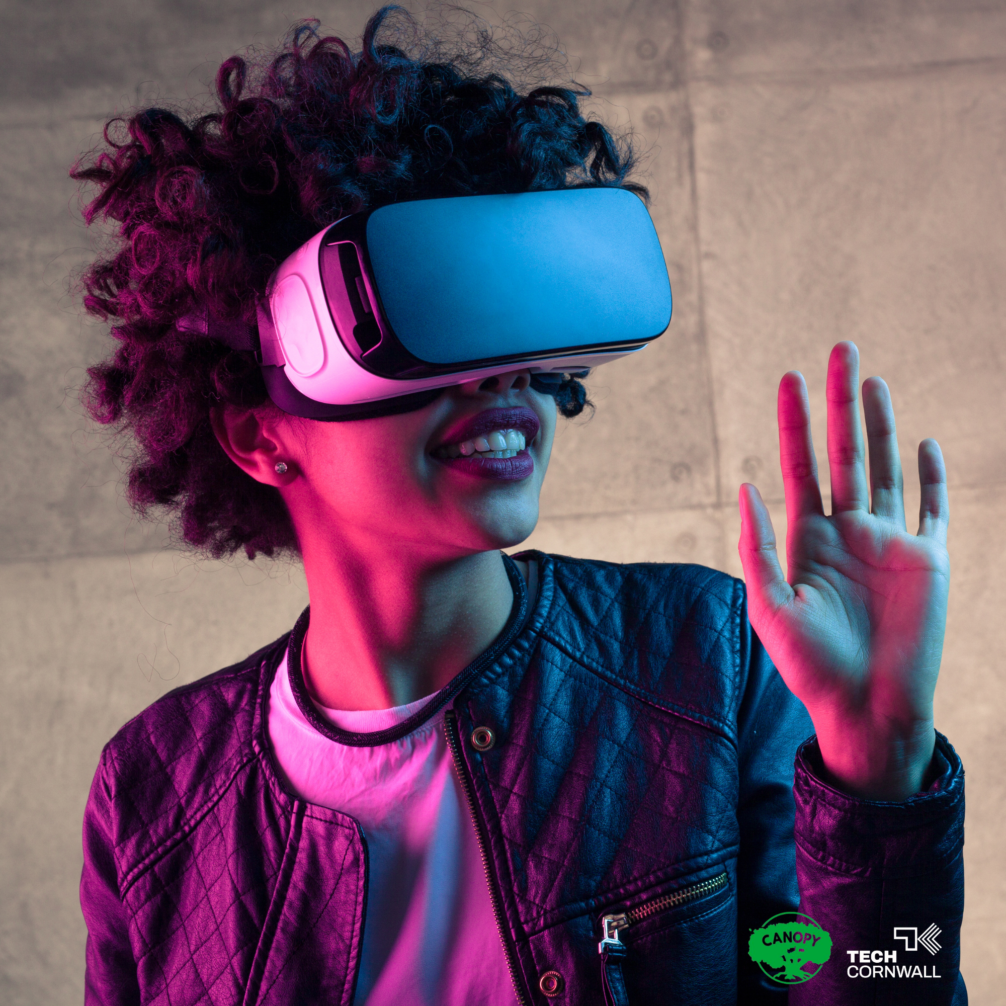 A woman demoing VR lit with pink and blue lights.