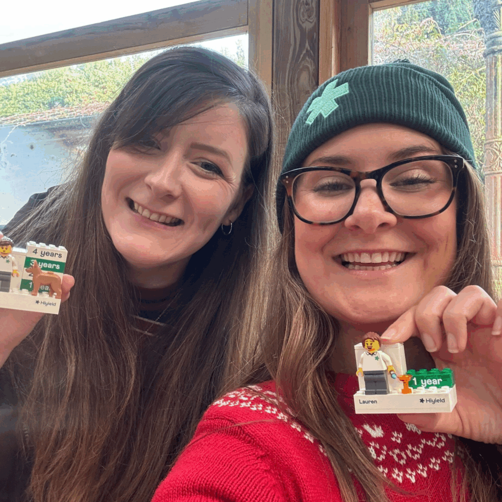Rachel and Lauren from Hiyield holding their Hiyield Lego figures and plinths.