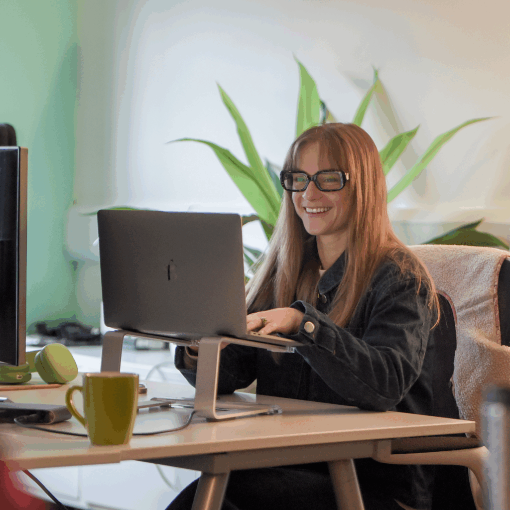 Sophie in the Hiyield office using her laptop.