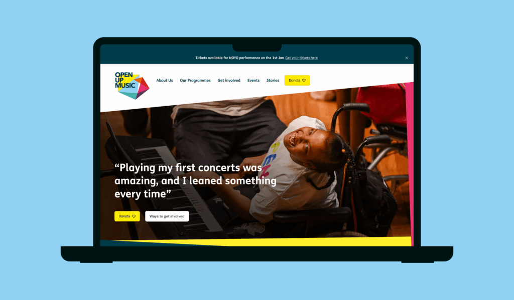The new Open Up Music website displayed on a laptop screen with a blue background.