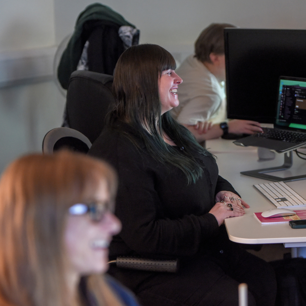 Photo of Lyssa sat at her desk in the Hiyield office with Sophie in the foreground.
