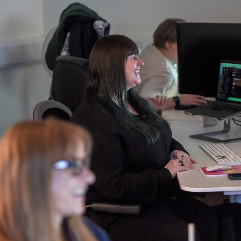 Photo of Lyssa sat at her desk in the Hiyield office with Sophie in the foreground.